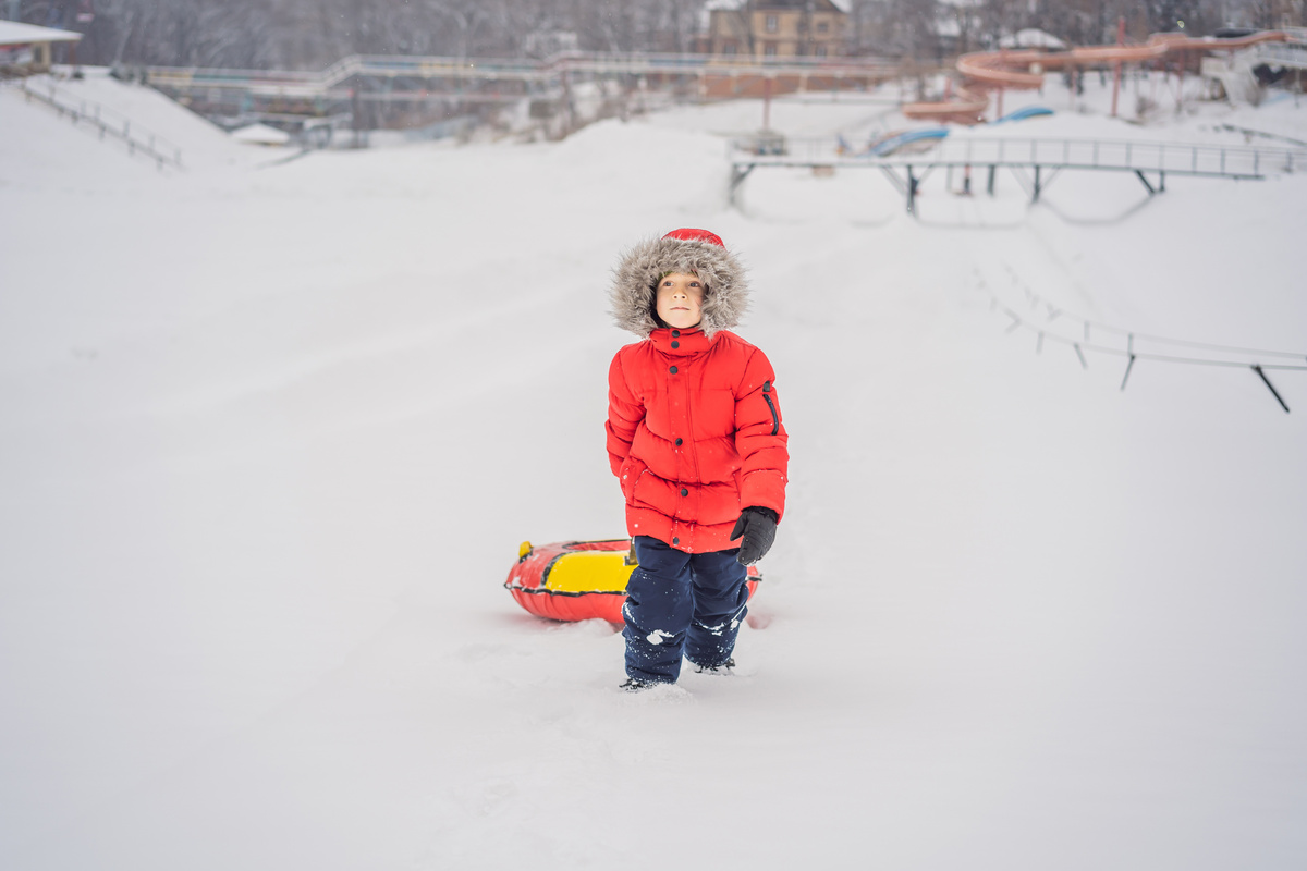 Child Having Fun on Snow Tube